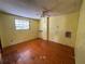 Bedroom featuring yellow wood paneled walls, a window, and hardwood flooring at 1920 Baxter Ave, Orlando, FL 32806
