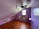 Attic bedroom featuring a ceiling fan, a window, and purple painted walls at 1920 Baxter Ave, Orlando, FL 32806