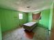 Bedroom featuring green wood paneled walls, one window, and carpeted flooring at 1920 Baxter Ave, Orlando, FL 32806
