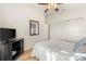 Bedroom features wood floors, ceiling fan, television on stand, and sliding-door closet at 2036 Chesapeake Pl, The Villages, FL 32162
