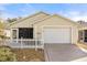 Charming single-story home with a well-manicured lawn, white picket fence, and attached garage at 2036 Chesapeake Pl, The Villages, FL 32162