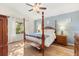 Comfortable main bedroom with a four-poster bed, hardwood floors, and natural light at 2036 Chesapeake Pl, The Villages, FL 32162