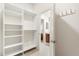 Walk-in closet with custom shelving and hanging rods, next to the doorway leading to the bathroom at 2036 Chesapeake Pl, The Villages, FL 32162