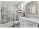 Well-lit bathroom showcasing a vanity with a marble countertop and tub with a world map shower curtain at 2120 Callaway Dr, The Villages, FL 32162
