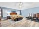 Spacious bedroom with blue walls, ceiling fan, and wood-style flooring at 2120 Callaway Dr, The Villages, FL 32162