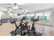Sunroom featuring multiple exercise bikes, ceiling fans, outdoor views, and a wet bar at 2120 Callaway Dr, The Villages, FL 32162