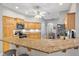 Bright kitchen with granite countertops, wooden cabinets, stainless steel appliances, and breakfast bar at 2120 Callaway Dr, The Villages, FL 32162