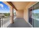 Covered balcony with wood-look flooring, metal railings, and sliding glass door at 2202 Garden Belle Dr, Clermont, FL 34711