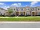 Charming two-story townhome featuring manicured lawn, covered porch with seating, and neutral color scheme at 2202 Garden Belle Dr, Clermont, FL 34711