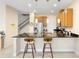 Open kitchen with granite countertops, stainless steel appliances, and a cozy breakfast bar at 2202 Garden Belle Dr, Clermont, FL 34711