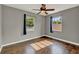 Bedroom with gray walls, wood floor, ceiling fan, and natural light at 2209 Hutchinson Ave, Leesburg, FL 34748