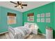 Bedroom with light green walls, ceiling fan, and a neutral color scheme at 2209 Hutchinson Ave, Leesburg, FL 34748
