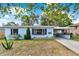 Charming single-story home featuring a well-kept front yard, covered carport, and freshly painted exterior at 2209 Hutchinson Ave, Leesburg, FL 34748