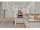 Compact kitchen featuring white appliances, white cabinetry and tiled countertops, offering practical cooking space at 2209 Hutchinson Ave, Leesburg, FL 34748