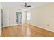Bedroom with hardwood floors, ceiling fan, and a partial view of an en-suite bathroom at 2401 Greenlaw Ct, Leesburg, FL 34788