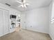A bedroom featuring an entertainment center, carpet flooring, and access to an en-suite bathroom at 2401 Greenlaw Ct, Leesburg, FL 34788