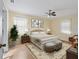 Well-lit bedroom with neutral decor, a ceiling fan, and a large window providing ample natural light at 2401 Greenlaw Ct, Leesburg, FL 34788