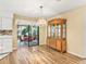A dining room with wood floors, sliding glass doors to the patio, and a large wooden china cabinet at 2401 Greenlaw Ct, Leesburg, FL 34788