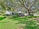 Charming single-story home with lush landscaping and a sprawling tree providing ample shade and curb appeal at 2401 Greenlaw Ct, Leesburg, FL 34788