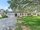 Traditional home with a well manicured lawn, attached garage and red window trim at 2401 Greenlaw Ct, Leesburg, FL 34788