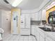 Kitchen with white cabinets and appliances, a brick-style backsplash, and a double-door refrigerator at 2401 Greenlaw Ct, Leesburg, FL 34788