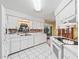 Bright and airy kitchen with white cabinets and brick backsplash opens to a patio view at 2401 Greenlaw Ct, Leesburg, FL 34788