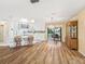 Open floor plan featuring wood flooring, white kitchen cabinets and a sliding glass door to the patio at 2401 Greenlaw Ct, Leesburg, FL 34788