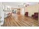 Open living room with wood flooring, white trim and neutral colored walls at 2401 Greenlaw Ct, Leesburg, FL 34788