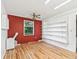 Empty spare room featuring wood floors, a ceiling fan, and built in shelving at 2401 Greenlaw Ct, Leesburg, FL 34788