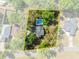 Aerial view of the property highlighting the home, pool, and surrounding mature trees at 25541 Troon Ave, Sorrento, FL 32776
