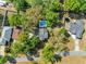 Overhead view shows a house, pool, trampoline and multiple houses and treed areas around it at 25541 Troon Ave, Sorrento, FL 32776