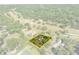 An aerial view showing a house and its property outlined in yellow within the landscape at 25541 Troon Ave, Sorrento, FL 32776