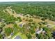Expansive aerial view of a property surrounded by lush greenery and trees, showcasing its private and serene setting at 25541 Troon Ave, Sorrento, FL 32776
