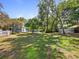 A large backyard with mature landscaping, a pool, and lush trees at 25541 Troon Ave, Sorrento, FL 32776