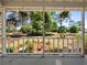 View from back porch showcases a large lawn, flowering plants and lush green trees at 25541 Troon Ave, Sorrento, FL 32776