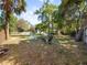 A backyard with fire pit, seating, mature trees, and white picket fence at 25541 Troon Ave, Sorrento, FL 32776