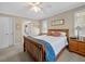 Bright bedroom featuring carpet, ceiling fan, wood frame bed, and a door leading to the bathroom at 25541 Troon Ave, Sorrento, FL 32776