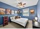 Bedroom with blue painted walls, natural light, ceiling fan and decorative artwork at 25541 Troon Ave, Sorrento, FL 32776