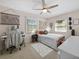 Bright bedroom features a large window, ceiling fan, white bed frame and a vanity desk at 25541 Troon Ave, Sorrento, FL 32776