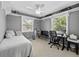 Grey bedroom with natural light, shelving units, ceiling fan, and space for a desk at 25541 Troon Ave, Sorrento, FL 32776