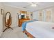 Bright bedroom with carpet, ceiling fan and white bedding with a blue blanket, and ample closet space at 25541 Troon Ave, Sorrento, FL 32776