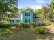 Charming two-story home with a front porch, lush landscaping, and mature trees in a desirable neighborhood at 25541 Troon Ave, Sorrento, FL 32776