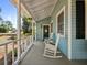 Charming front porch with rocking chairs and a welcoming wreath on the door at 25541 Troon Ave, Sorrento, FL 32776