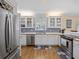 Bright kitchen with white cabinets, stainless steel appliances, and hardwood floors at 25541 Troon Ave, Sorrento, FL 32776