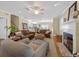 Spacious living room with hardwood floors, a fireplace, and plenty of seating for entertaining guests at 25541 Troon Ave, Sorrento, FL 32776