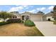 Well-maintained home with lush landscaping, arched entryway, and attached garage at 2706 Radbourne Way, The Villages, FL 32162