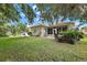 Lush backyard features a covered patio area, mature landscaping, and a serene outdoor retreat at 3584 Tropical Seas Loop, Tavares, FL 32778