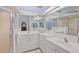 Bathroom featuring dual sinks, vanity, large mirror, walk-in shower, and tile flooring at 3584 Tropical Seas Loop, Tavares, FL 32778