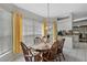 Dining area with wood table, seating for six, and large windows with bright yellow curtains at 3584 Tropical Seas Loop, Tavares, FL 32778