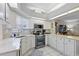 Bright kitchen with white cabinets, tile floors, stainless steel appliances, and view to the living area at 3584 Tropical Seas Loop, Tavares, FL 32778